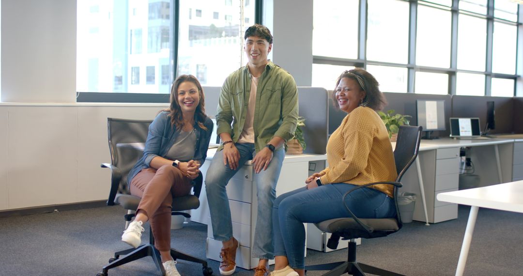 Smiling diverse team collaborating in modern bright office with casual seating