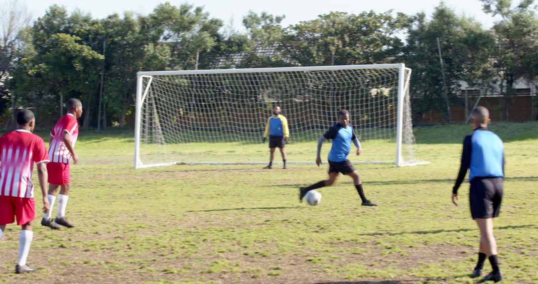 African American Men Playing Soccer on Grass Field by Goal