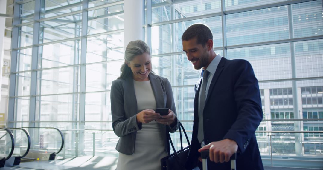 Business Colleagues Using Smartphone in Modern Office Building