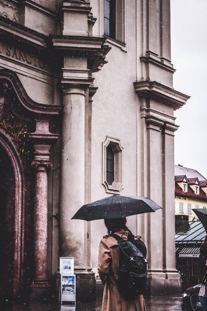 Person with Umbrella by Historical Building on Rainy Day - Free Images, Stock Photos and Pictures on Pikwizard.com