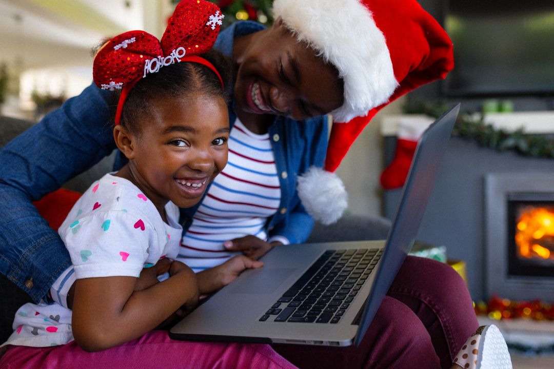 Happy African American Grandmother and Granddaughter Using Laptop at Christmas - Free Images, Stock Photos and Pictures on Pikwizard.com