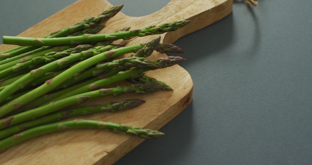 Image of asparagus on wooden chopping board over grey background - Free Images, Stock Photos and Pictures on Pikwizard.com