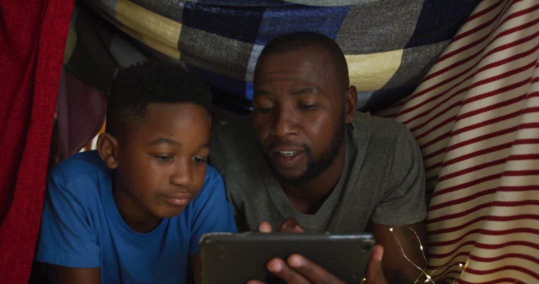 Father and Son Using Tablet in Blanket Fort - Free Images, Stock Photos and Pictures on Pikwizard.com