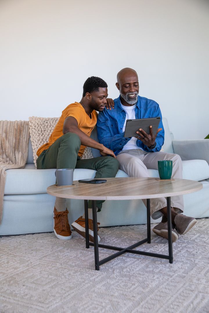Father and Son Bonding over Tablet on Cozy Sofa