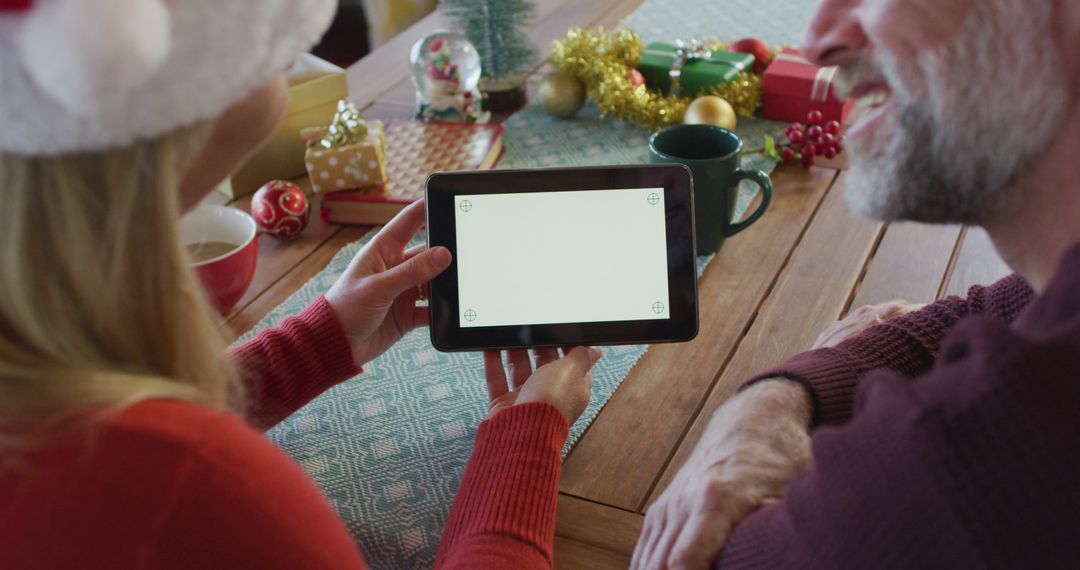 Couple Sharing Digital Tablet During Christmas Celebration - Free Images, Stock Photos and Pictures on Pikwizard.com