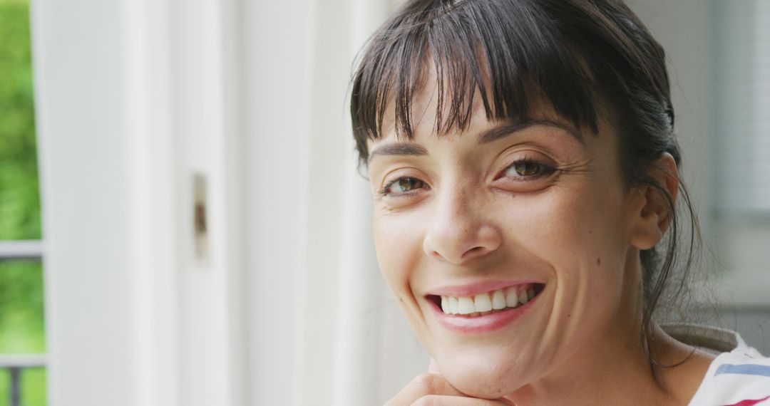 Smiling Woman by Window with Sunlight - Free Images, Stock Photos and Pictures on Pikwizard.com