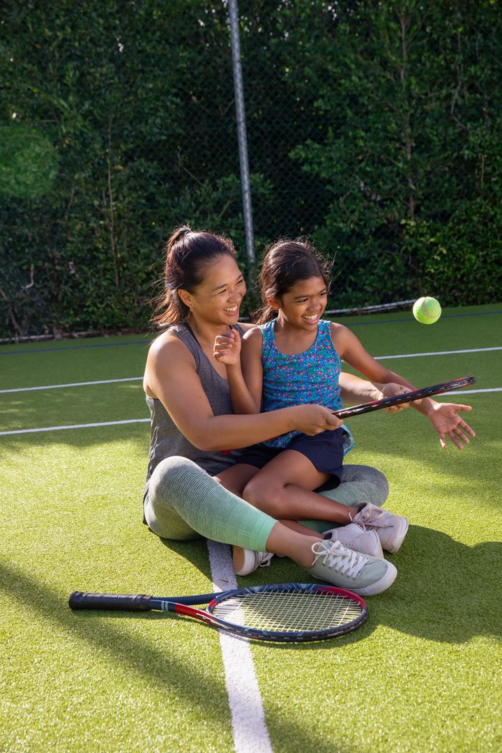 Mother Teaching Daughter Tennis on Sunny Day Outdoor Sports Fun
