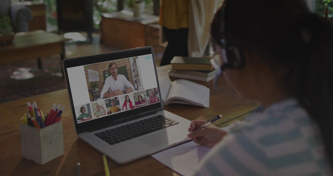 Student Engaged in Online Class Using Laptop and Headset at Home