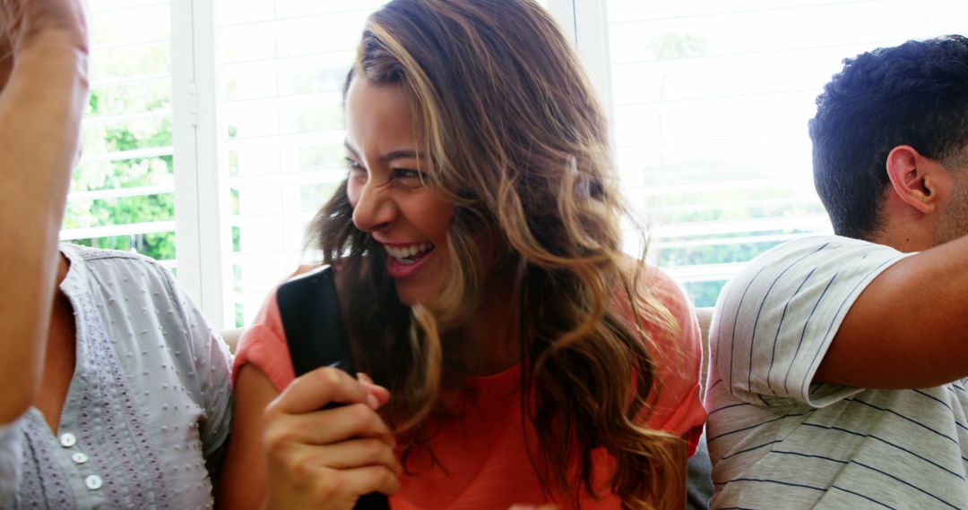 Happy young woman laughing with friends indoors - Free Images, Stock Photos and Pictures on Pikwizard.com