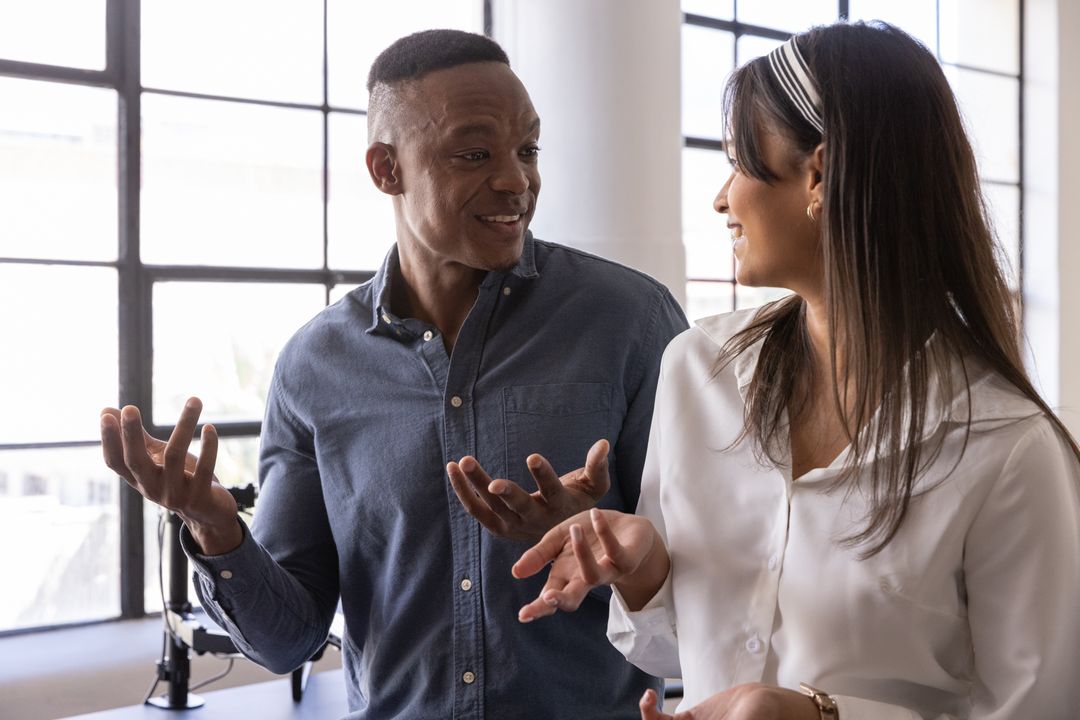 Diverse Coworkers Engaging in Conversation at Modern Office