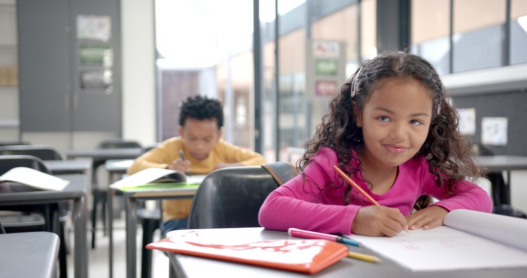 Young Girl Drawing in Classroom with Classmate and Educational Decor