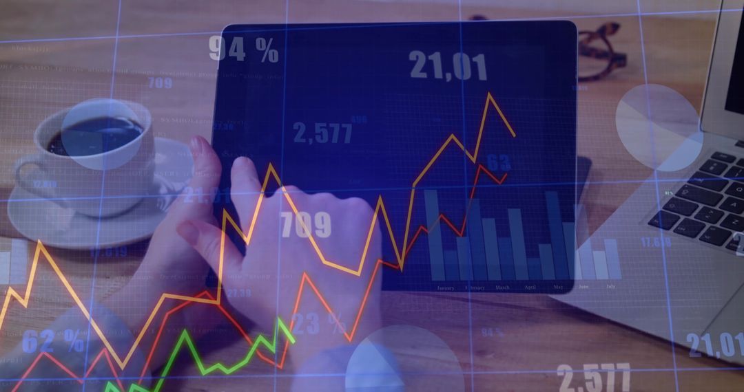 Analyzing Data on Tablet with Coffee and Laptop in Modern Workspace