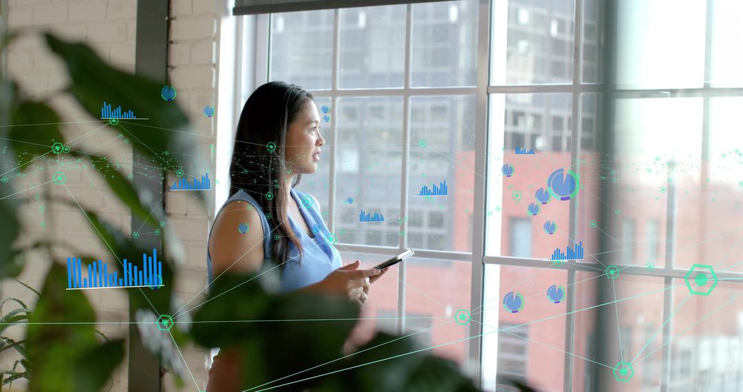 Asian Businesswoman Analyzing Data Graphs in Modern Office Setting