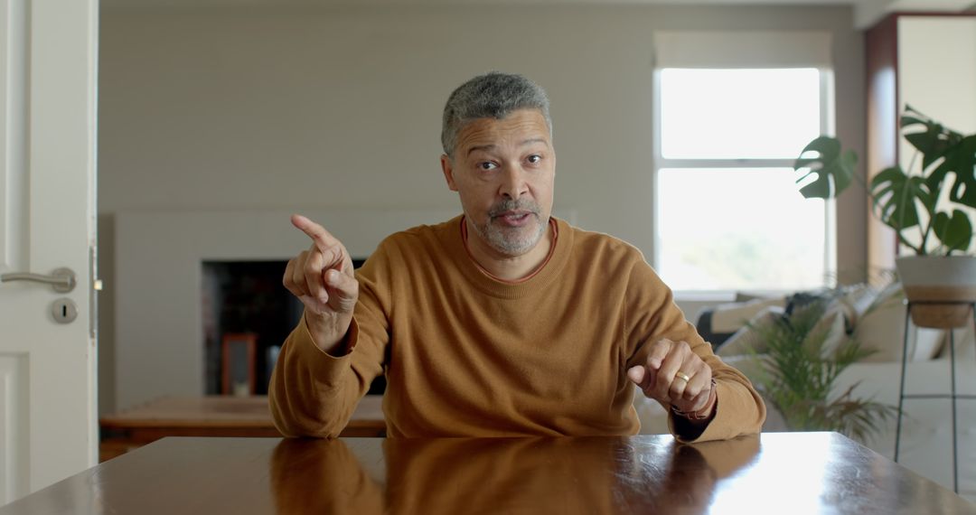 Senior Man Gesturing While Engaging in Conversation at Home