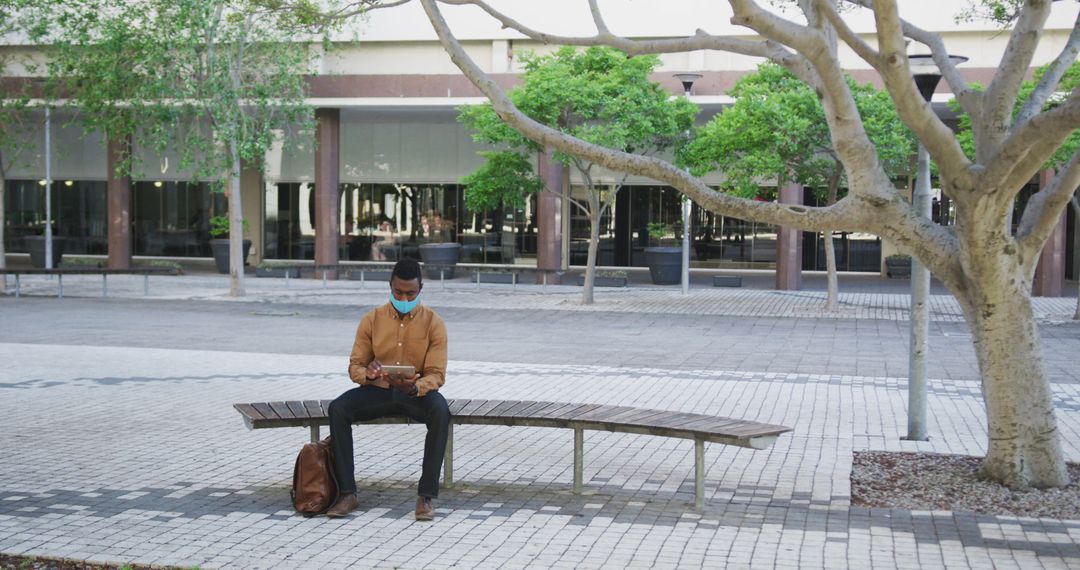 Man Wearing Face Mask Sitting on Bench in Urban Area - Free Images, Stock Photos and Pictures on Pikwizard.com