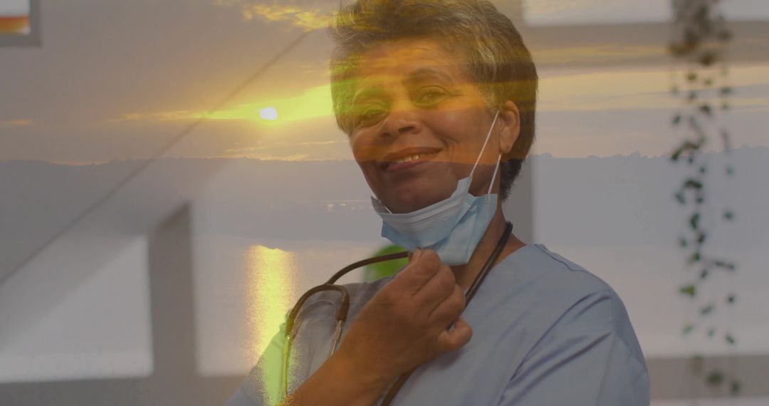 Smiling Nurse Lowering Mask with Stethoscope at Window during Golden Hour Double Exposure