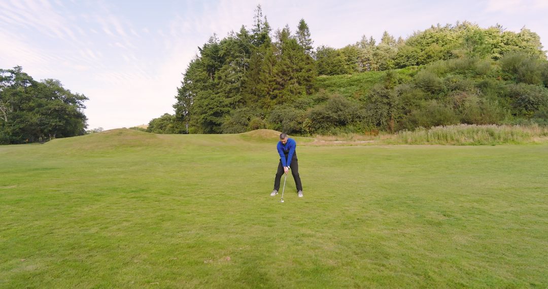 Man Preparing to Hit Golf Shot on Sunny Fairway