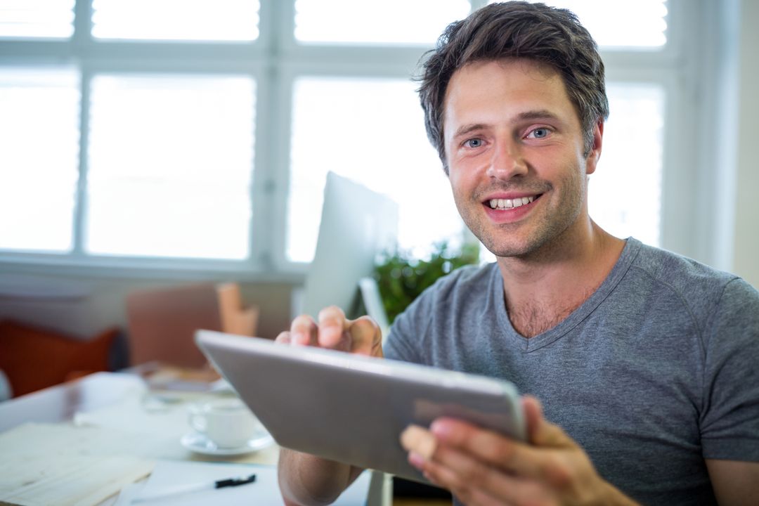Smiling Professional Man Using Digital Tablet at Office Desk
