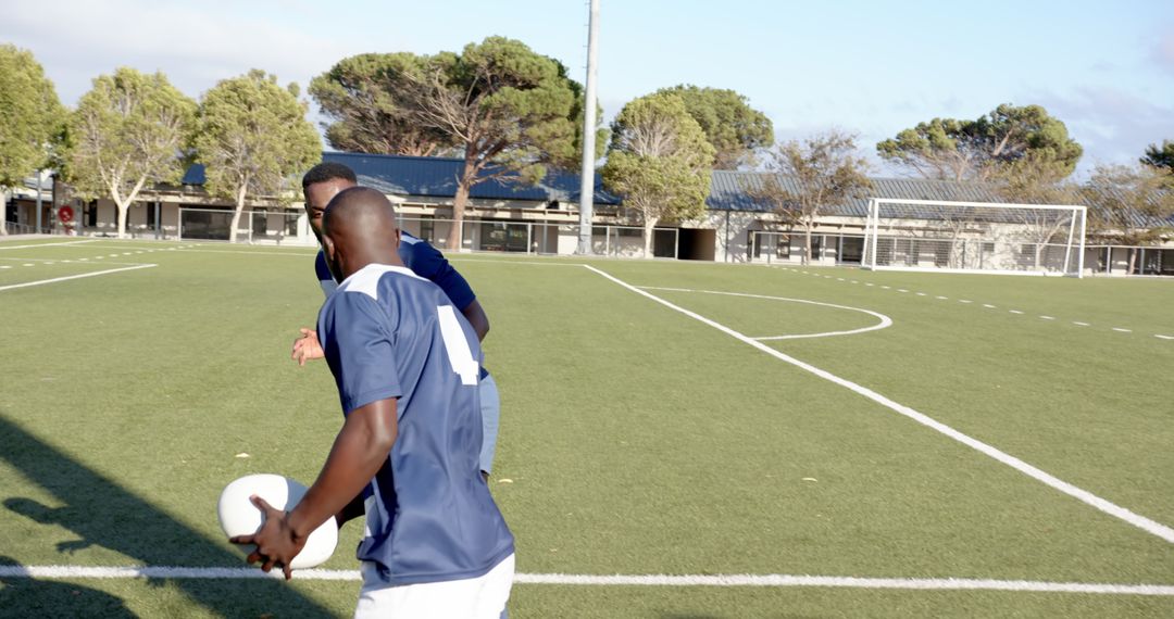 Soccer Players Strategizing on Field with Ball