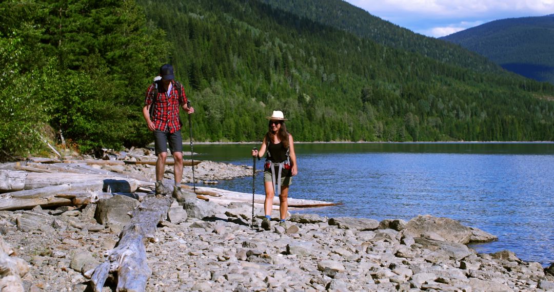 Two Hikers Walking Along Rocky Lakeshore With Mountain Views - Free Images, Stock Photos and Pictures on Pikwizard.com