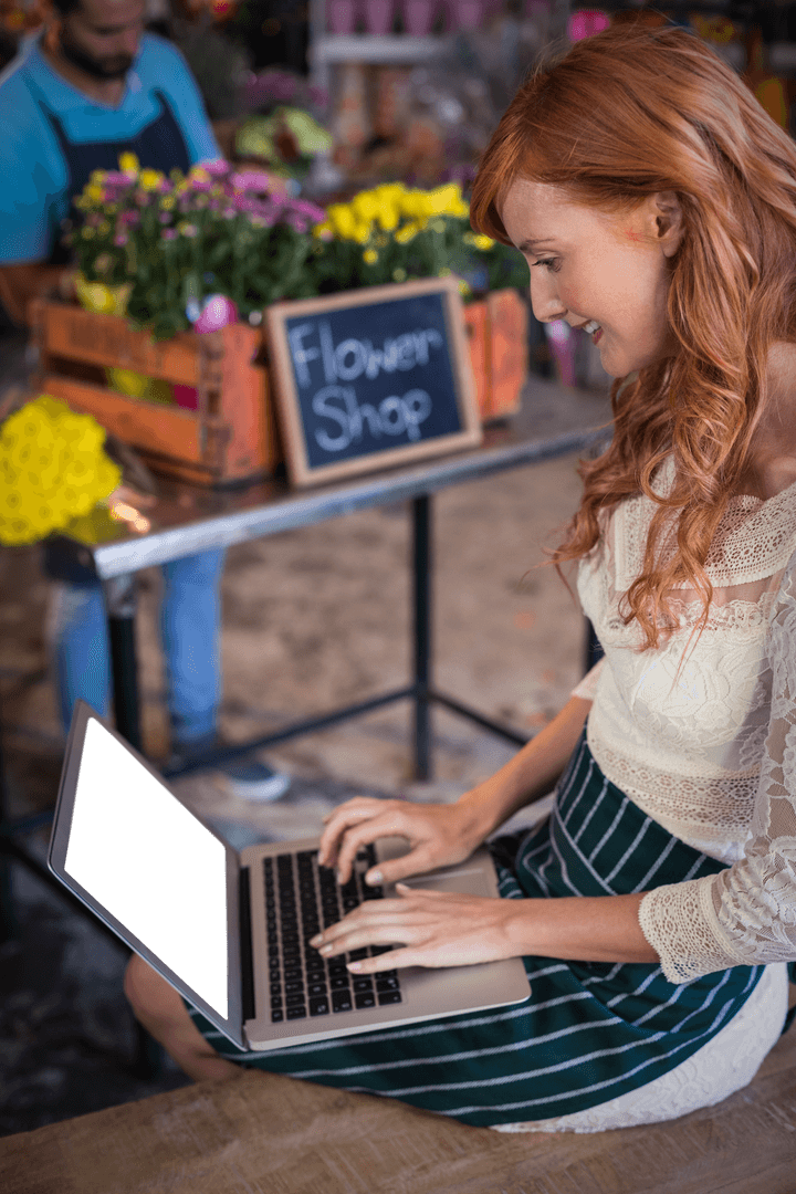 Delighted Florist Using Transparent Laptop in Flower Shop