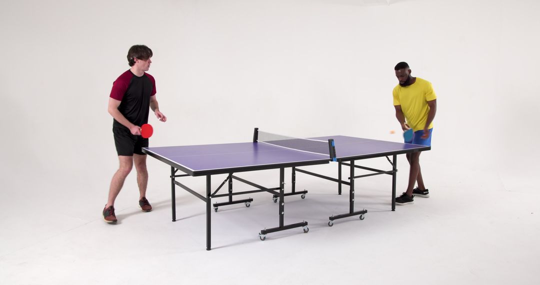 Male Friends Energetically Playing Ping Pong with Colorful Gear