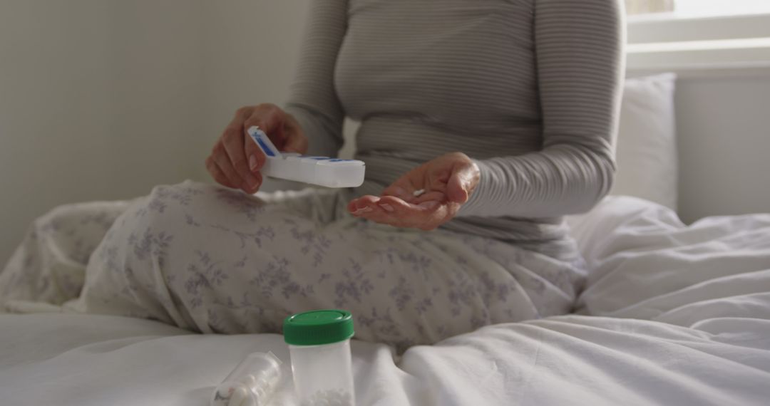 Woman Taking Medication in Morning While Sitting on Bed in Pyjamas - Free Images, Stock Photos and Pictures on Pikwizard.com