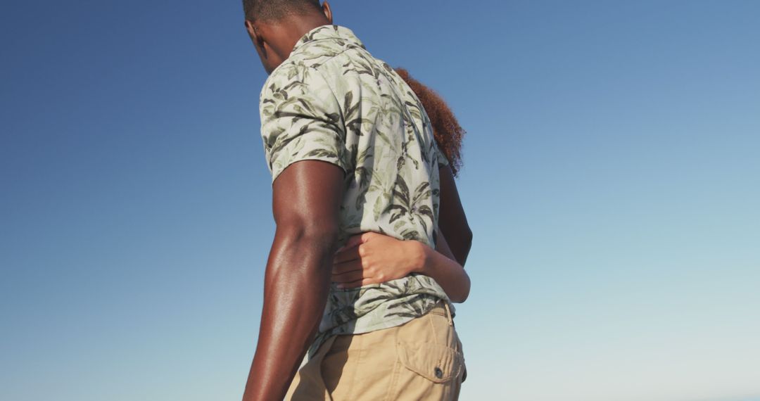 Couple Embracing While Standing Outdoors Under Clear Blue Sky - Free Images, Stock Photos and Pictures on Pikwizard.com