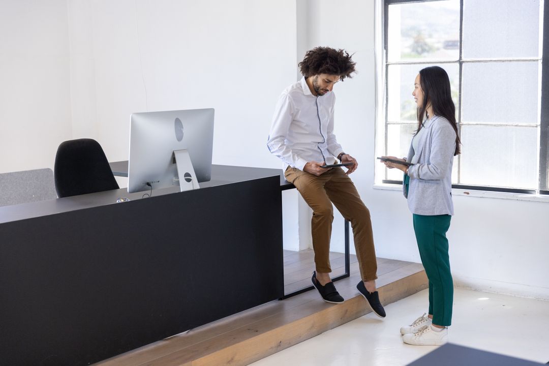 Diverse Coworkers Collaborating at Office Reception Desk