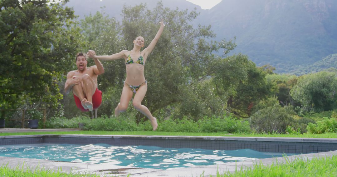 Joyful Couple Jumping into Pool for Summer Fun