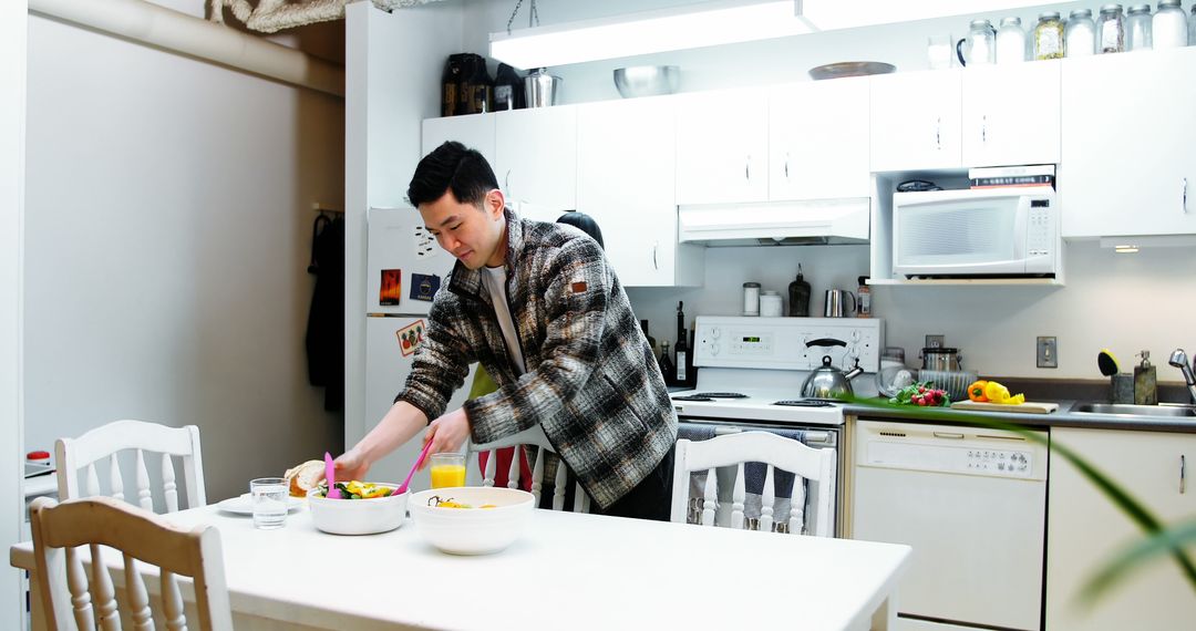 Young Man Preparing Meal in Bright Modern Kitchen - Free Images, Stock Photos and Pictures on Pikwizard.com