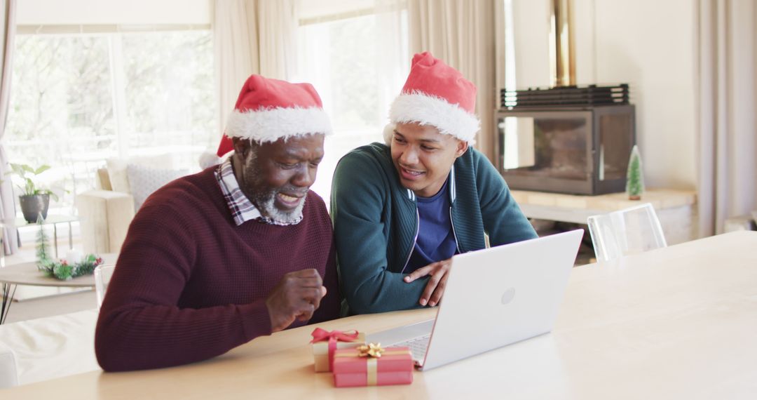 Father and Son Wearing Santa Hats Using Laptop in Festive Home - Free Images, Stock Photos and Pictures on Pikwizard.com