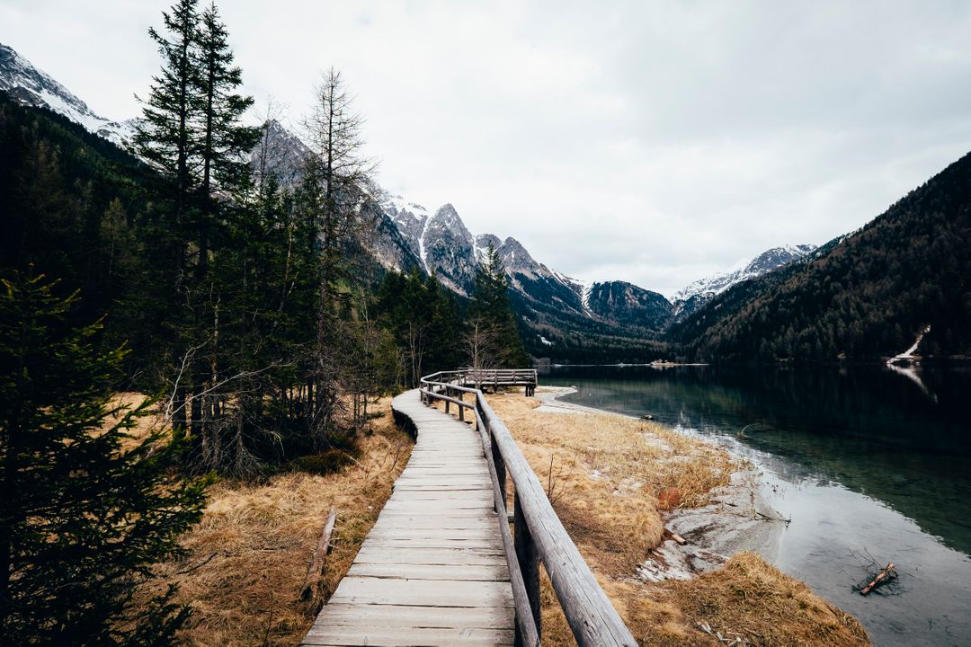 Scenic Wooden Pathway through Mountain Landscape Near Calm Lake - Free Images, Stock Photos and Pictures on Pikwizard.com