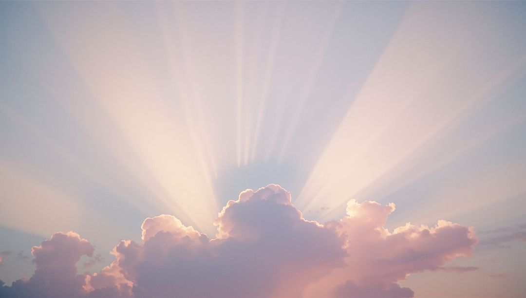 Serene Dawn with Radiant Sun Rays Illuminating Pastel Clouds