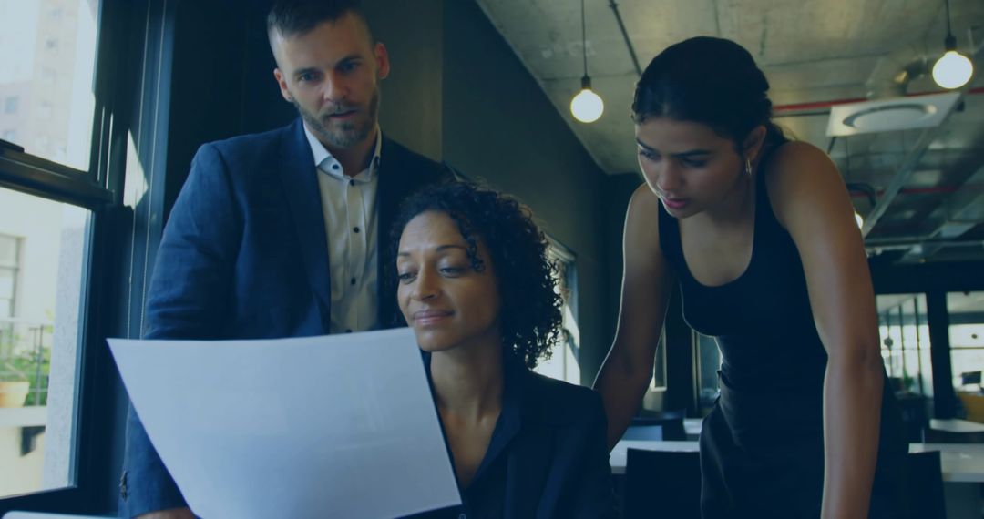 Multicultural team reviewing report in modern open-plan office for strategic planning