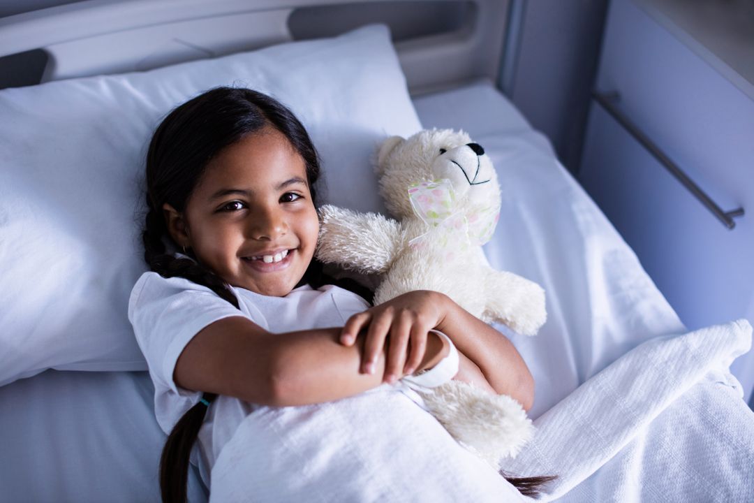 Smiling Girl in Hospital Bed with Teddy Bear - Free Images, Stock Photos and Pictures on Pikwizard.com