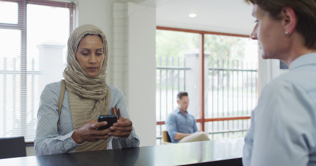 Muslim Woman Processing Transaction in Modern Bank - Free Images, Stock Photos and Pictures on Pikwizard.com