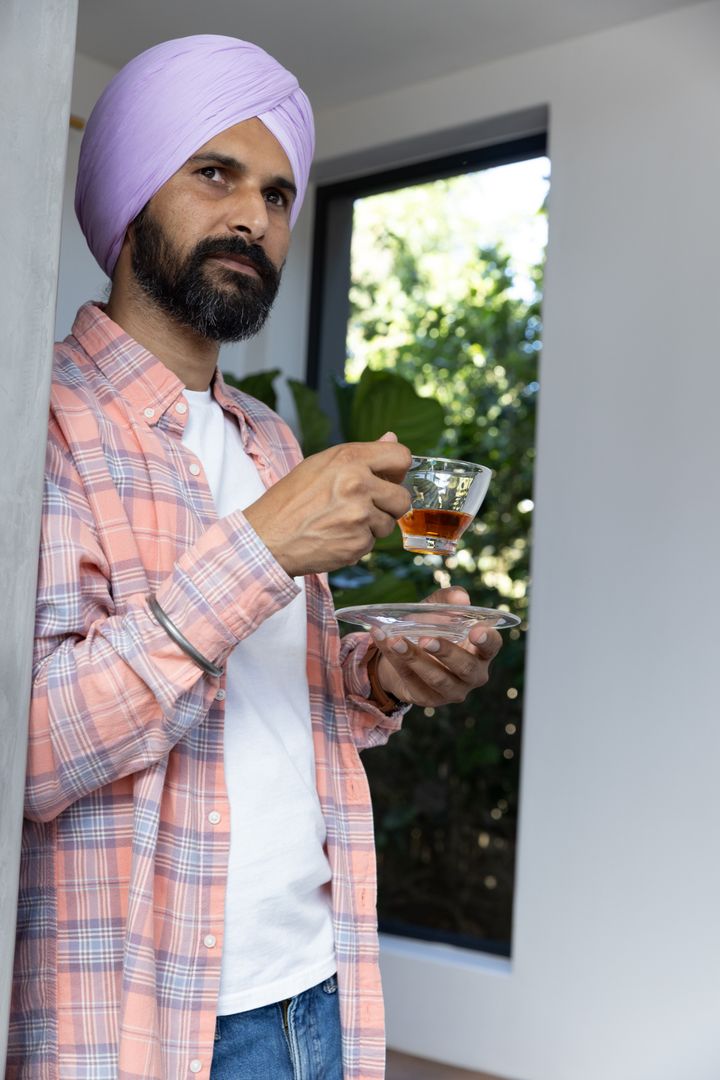 Man Wearing Turban Enjoying Tea at Home in Relaxed Setting
