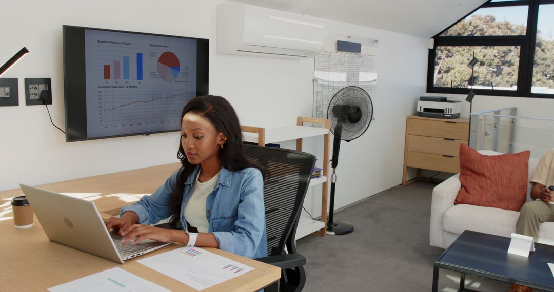 Professional in Modern Office Analyzing Data on Laptop and Display