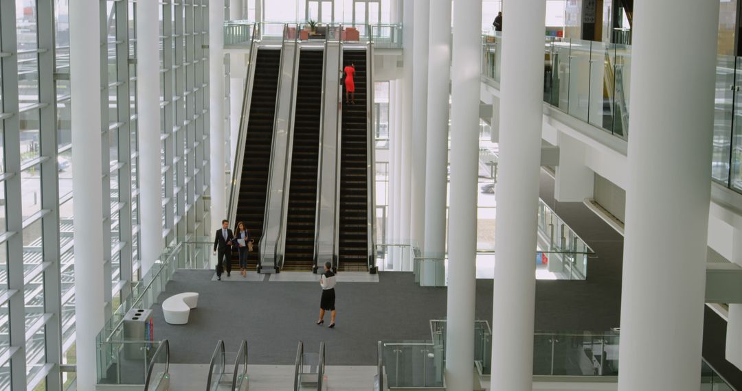 Modern Office Lobby with Escalators and People Interacting - Free Images, Stock Photos and Pictures on Pikwizard.com