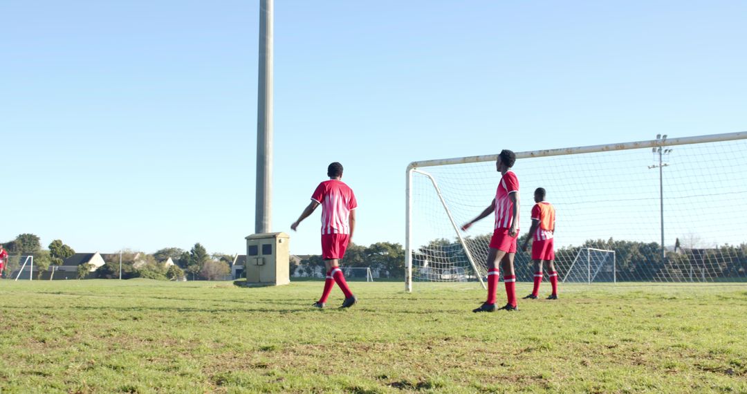 Team Practicing Soccer Around Goalpost on Park Field