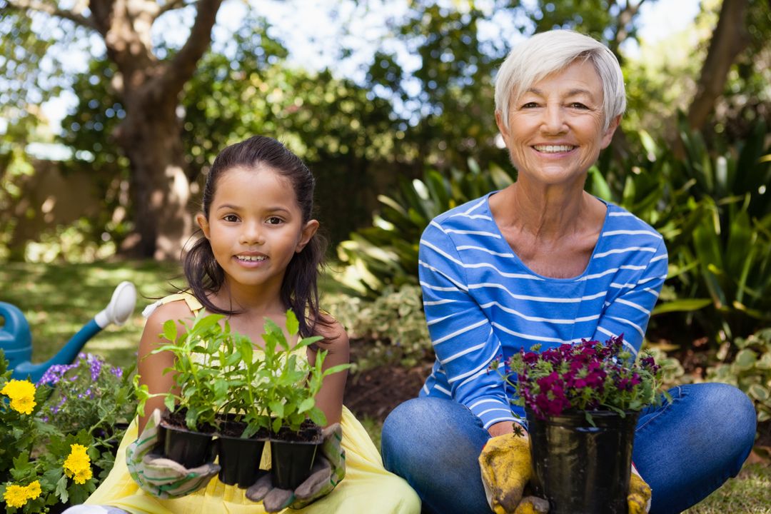Portrait of smiling girl and granddaughter sitting while holding plants - Free Images, Stock Photos and Pictures on Pikwizard.com