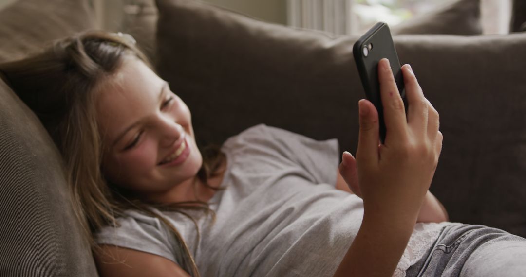 Smiling Teenage Girl Relaxing on Couch Using Smartphone - Free Images, Stock Photos and Pictures on Pikwizard.com