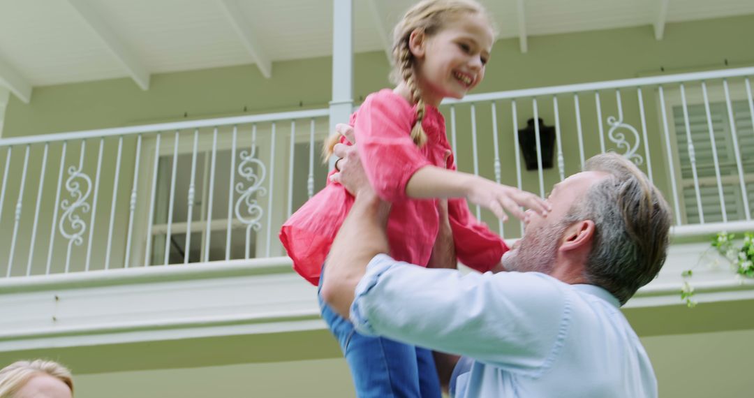 Father Lifting Happy Daughter Outdoors in Sunny Backyard - Free Images, Stock Photos and Pictures on Pikwizard.com