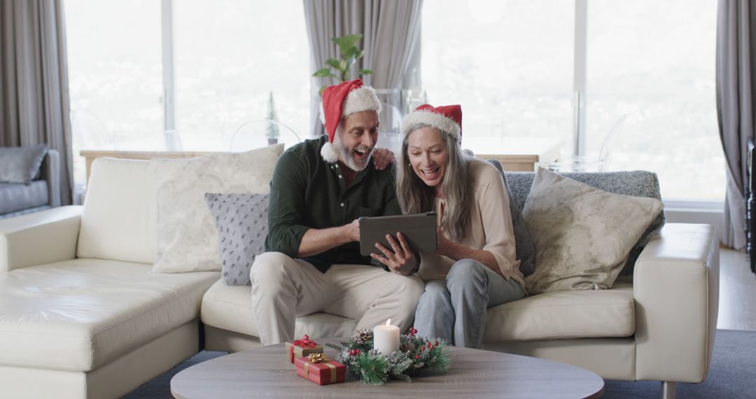 Happy Senior Couple in Santa Hats Video Calling on Tablet During Christmas Celebration - Free Images, Stock Photos and Pictures on Pikwizard.com