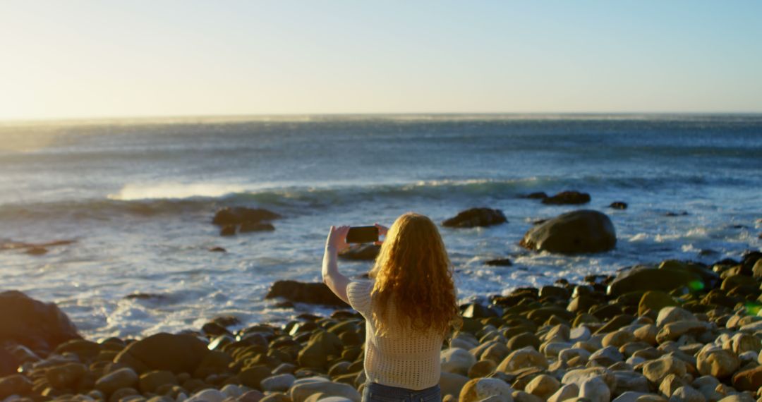 Woman Taking Photo of Scenic Ocean View at Rocky Beach - Free Images, Stock Photos and Pictures on Pikwizard.com