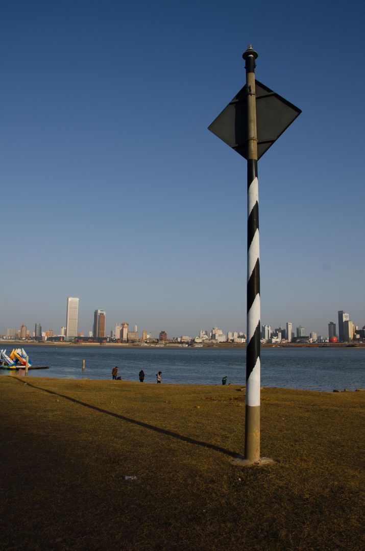 Coastal City Skyline from Park with Chevron Pole and Distant Buildings - Free Images, Stock Photos and Pictures on Pikwizard.com