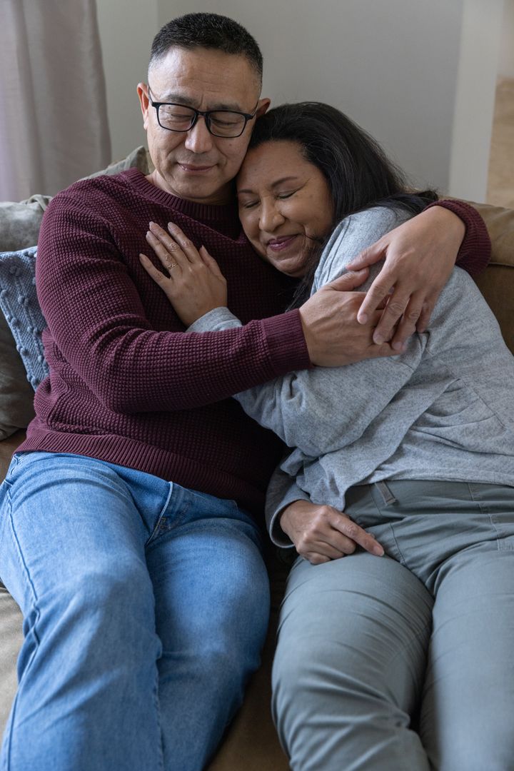Happy Couple Embracing in Comfortable Living Space with Focus on Warmth