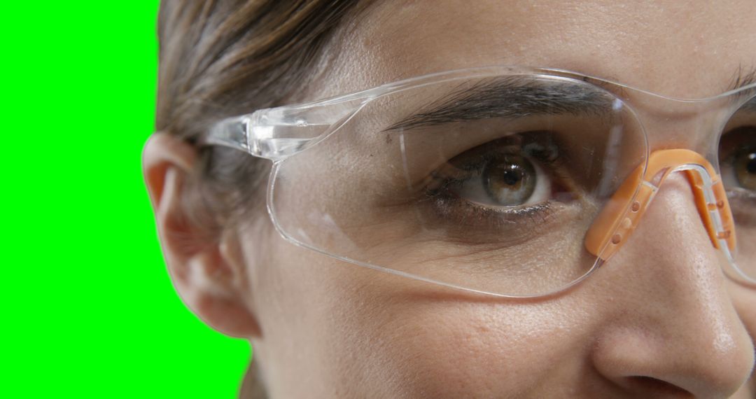 Close-up of Woman Wearing Safety Goggles Isolated on Green Background - Free Images, Stock Photos and Pictures on Pikwizard.com