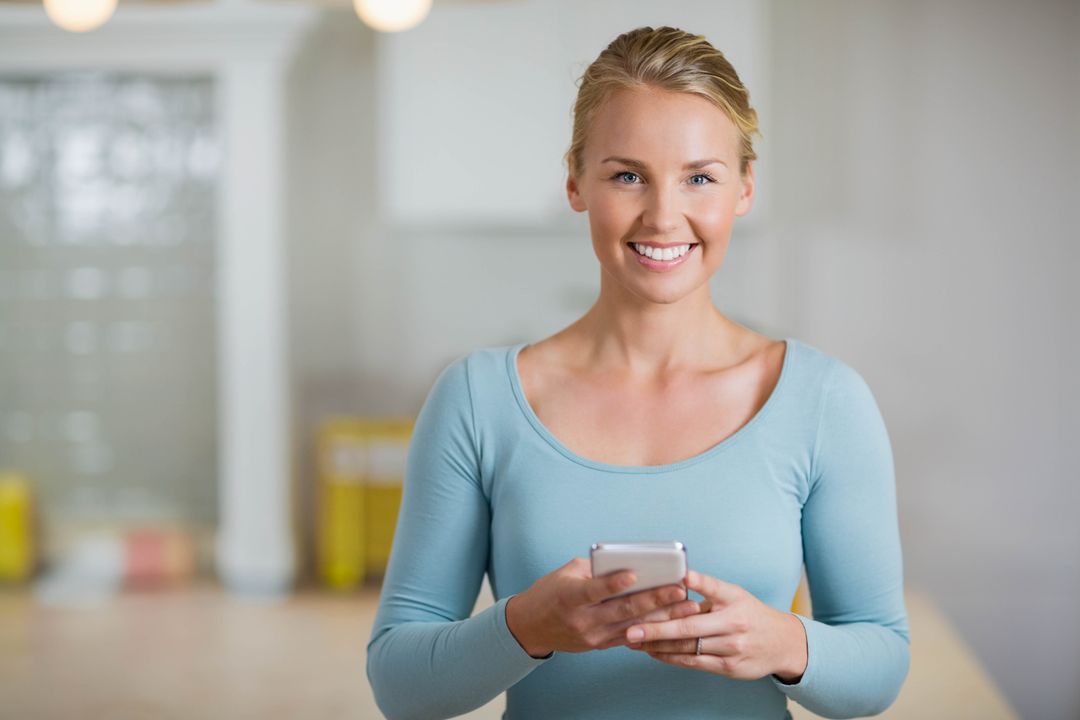 Professional Woman Using Smartphone in Bright Workspace